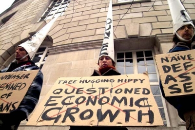 IndyMedia Manchester photo: person with dunce hat and sign 'tree hugging hippy: questioned economic growth'